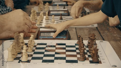 men play chess with a clock in the Park