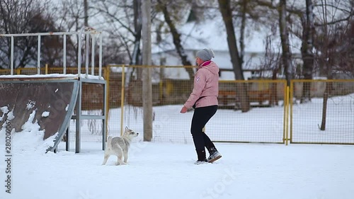 girl playing with a white dog winter snow happiness