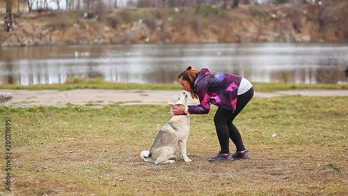 Beautiful girl playing with siberian husky puppy in the park,vintage filter