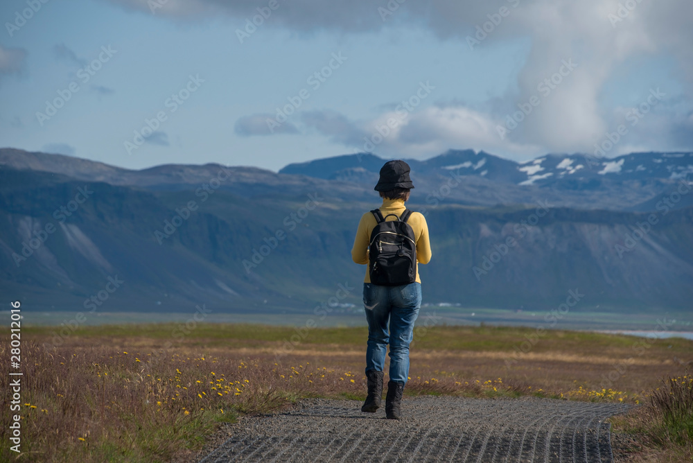 Backpacker woman Wearing jeans, hiking and trekking in Iceland .Travel vacation and summer  time  concept.