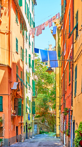 Italian street with drying laundry on sunny summer day