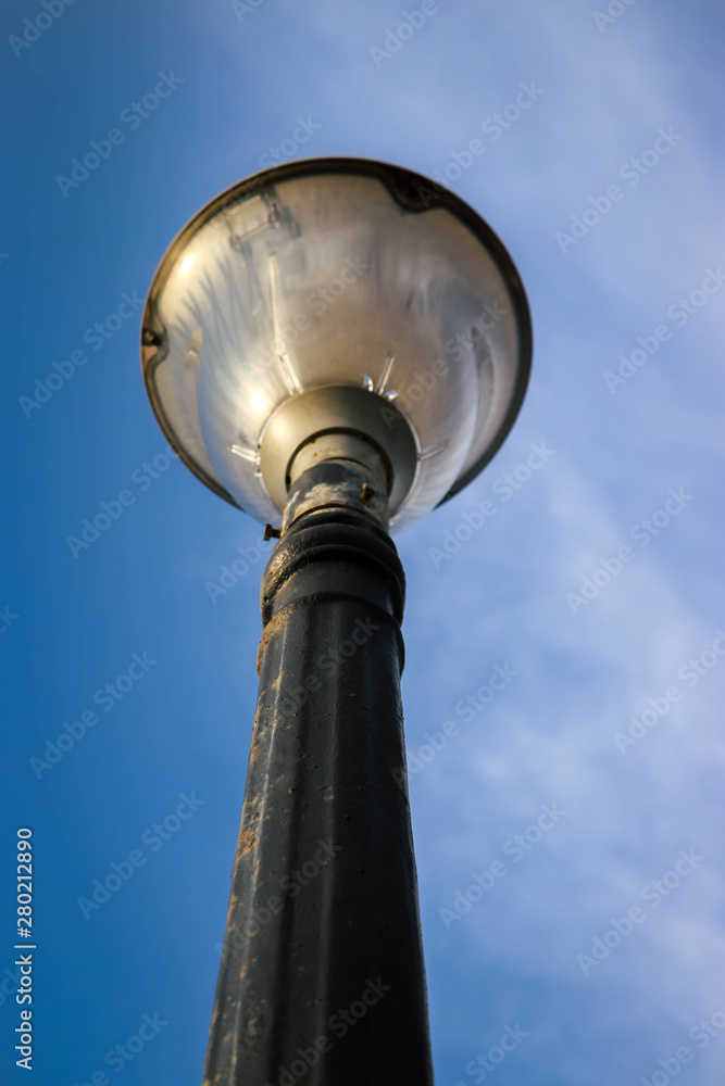 Old decorative streetlamp standing below the sky Old decorative streetlamp standing below the sky