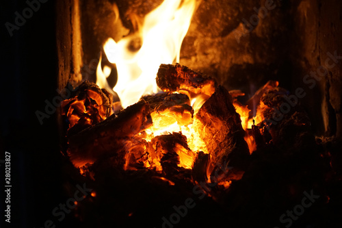In a rustic stove a hot fire burns. Heat fireplace, background