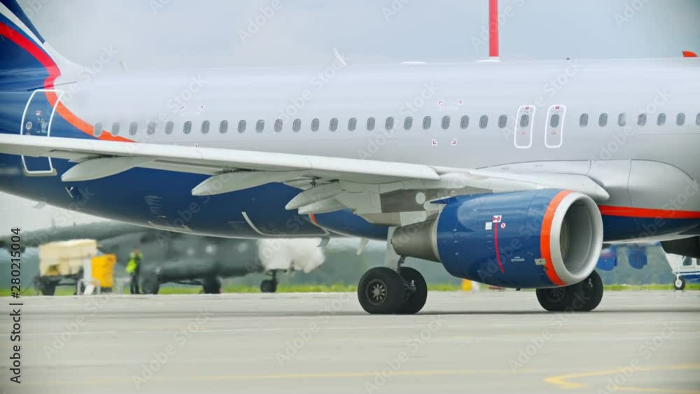 An airplane standing on the airport field - working turbine - warm air An airplane standing on the airport field - working turbine - warm air