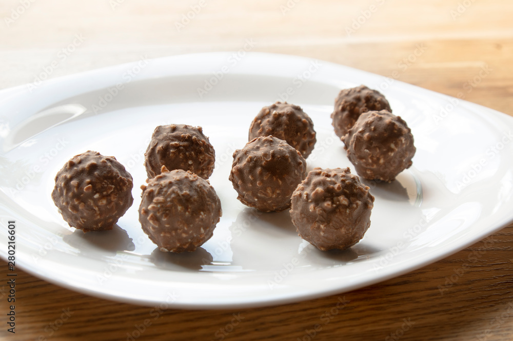 round chocolate with nuts on a white plate round chocolate with nuts on a white plate