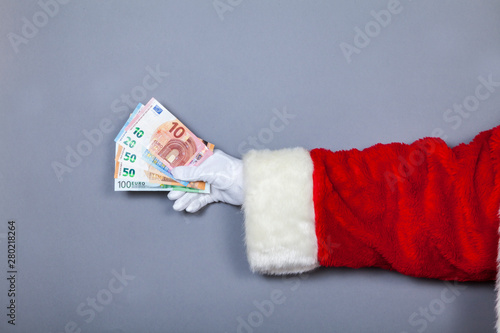 Weihnachtsmann hält Euro Noten in der Hand photo