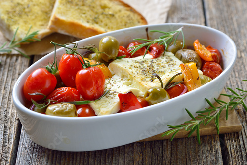 Foto Griechische Vorspeise: Gebackener Feta mit Oliven, Tomaten, Paprika, Zwiebeln un
