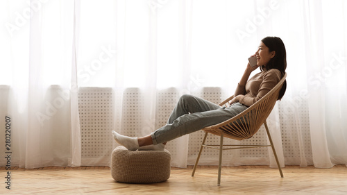 Girl Resting in Armchair and Talking on Phone