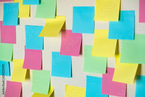 Sticky paper notes on a planning board. Planning, brainstorm, diversity or fresh ideas concept - pattern of empty multicolored paper notes