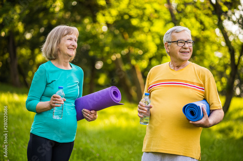 Happy senior couple is ready for exercising in park. 