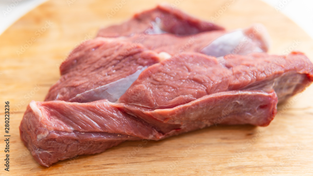 Fresh slice of beef close-up. Preparation for cooking red meat with spice and tomato. Fresh slice of beef close-up. Preparation for cooking red meat with spice and tomato.