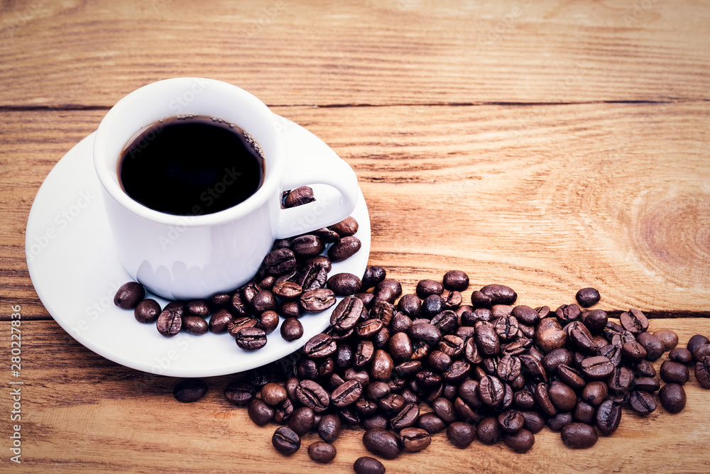 A cup of coffee and scattered coffee beans. Layout. Flat lay. Coffee bean. A cup of coffee and scattered coffee beans. Layout. Flat lay. Coffee bean.