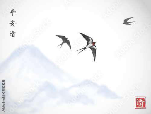 Flying swallow birds and blue mountain. Traditional Japanese ink wash painting sumi-e. Hieroglyphs - peace, tranquility, clarity.