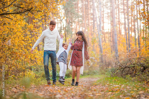 Mom, Dad and Daughter are walking in the autumn forest © ribalka yuli