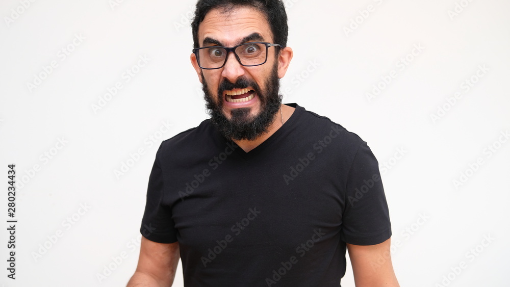 middle age bearded man in a white backround making an angry expression middle age bearded man in a white backround making an angry expression
