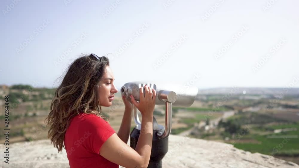 young woman looking through binoculars at malta mdina city young woman looking through binoculars at malta mdina city