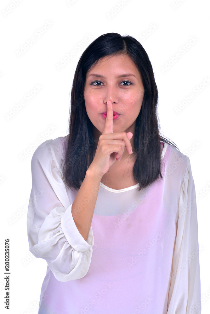 Portrait of attractive teenage girl with finger on lips, isolated over white background concept of student show quiet, silence, secret gesture, young pretty brunette woman Portrait of attractive teenage girl with finger on lips, isolated over white background concept of student show quiet, silence, secret gesture, young pretty brunette woman