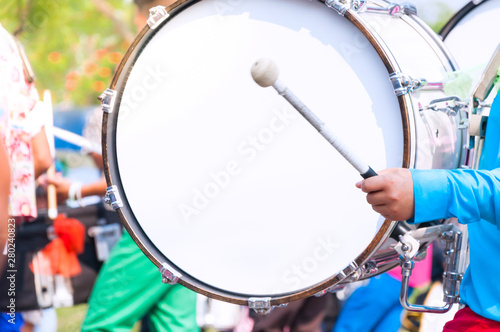 Drummer in blue uniforms a Marching Band. Drummer plays big drum in parade