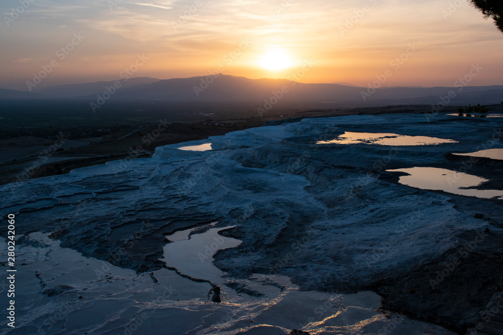 Turkey, sunset on the travertine terraces at Pamukkale (Cotton Castle), natural site of sedimentary rock deposited by water from the hot springs, famous for a carbonate mineral left by flowing water Turkey, sunset on the travertine terraces at Pamukkale (Cotton Castle), natural site of sedimentary rock deposited by water from the hot springs, famous for a carbonate mineral left by flowing water