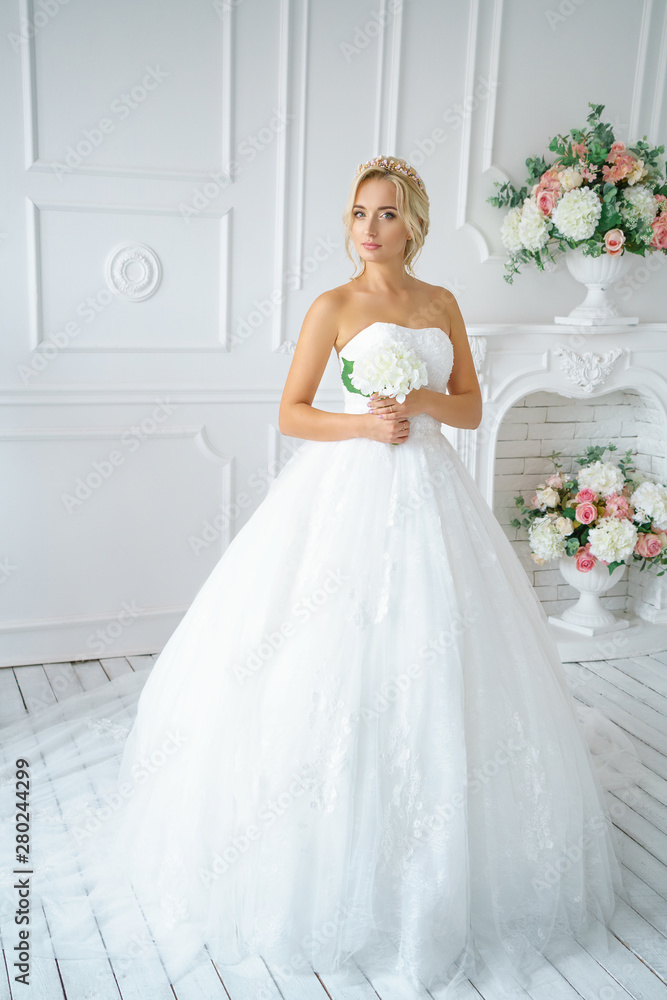 beautiful woman in a wedding dress with a beautiful make-up and hair in a white Studio beautiful woman in a wedding dress with a beautiful make-up and hair in a white Studio