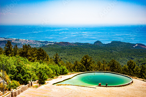 View from the mountain to the pool and the forest, the sea and the blue sky. © Sergey