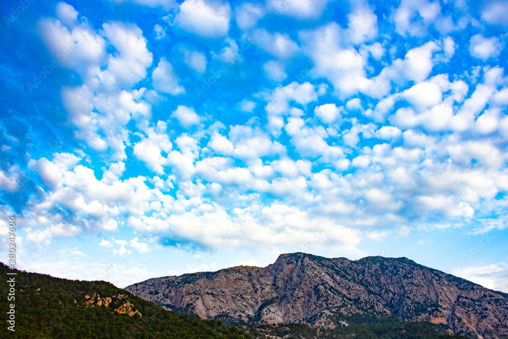 Mountain range with blue little cloudy sky.
