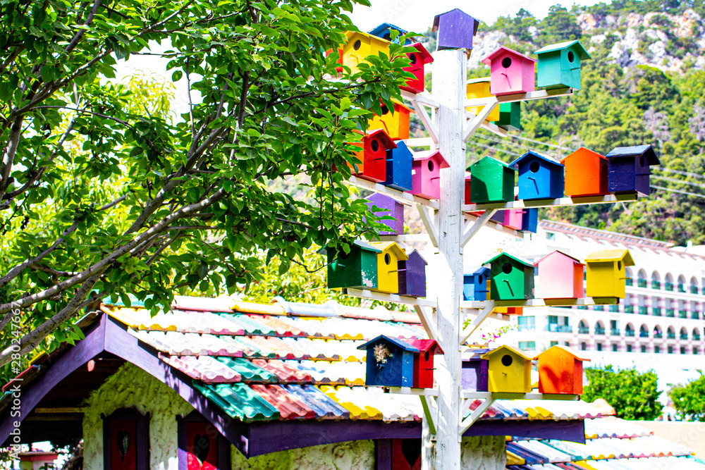 A pillar with multicolored nesting boxes.
