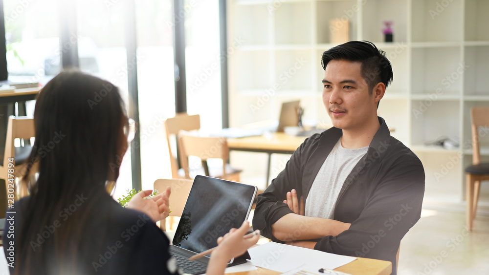 Young man and woman meeting a startup business women and man working in co working space.