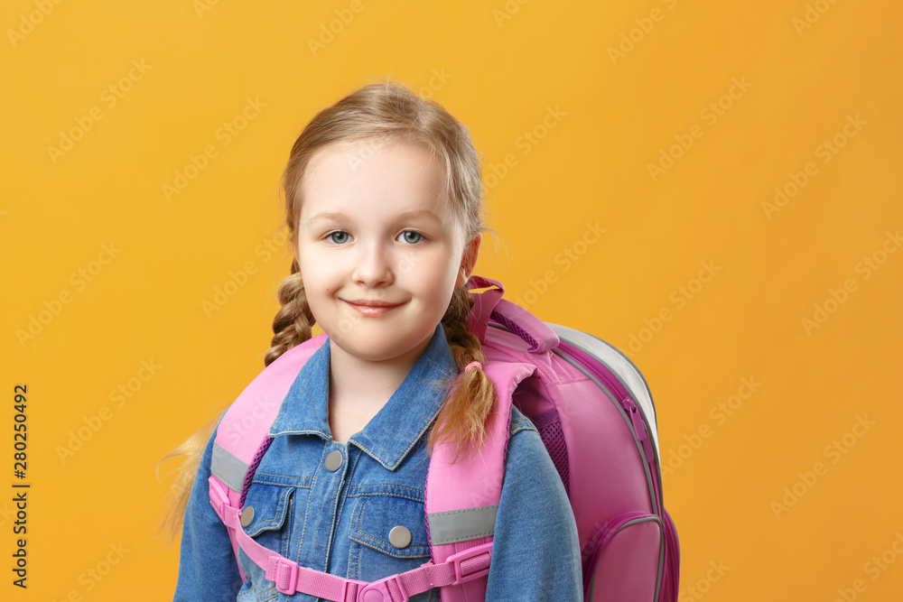 Portrait of a little girl schoolgirl with a backpack on a yellow background. Back to school. The concept of education. Copy space. Portrait of a little girl schoolgirl with a backpack on a yellow background. Back to school. The concept of education. Copy space.