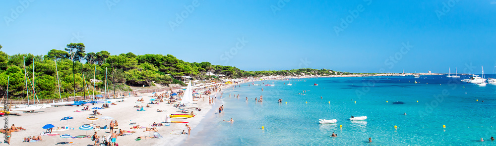 Panoramic image people swimming and sunbathing on the picturesque Las Salinas beach. Ibiza, Balearic islands. Spain