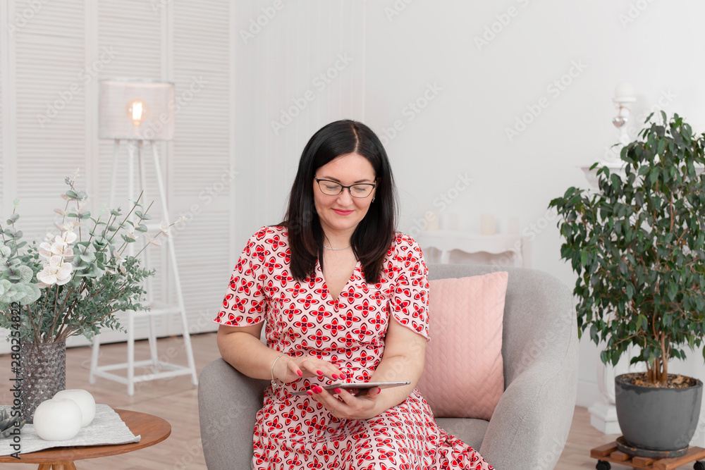 A professional doctor psychologist with glasses sits in a bright office with a tablet in his hands and smiles at the camera. Psychotherapy. Woman psychotherapist A professional doctor psychologist with glasses sits in a bright office with a tablet in his hands and smiles at the camera. Psychotherapy. Woman psychotherapist