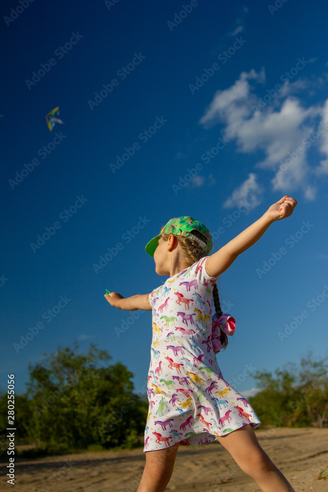 little girl in white flower dress and green cap play with kite in blue sky little girl in white flower dress and green cap play with kite in blue sky
