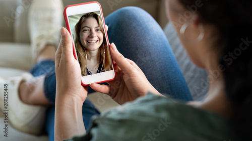 Young woman using smartphone for video call