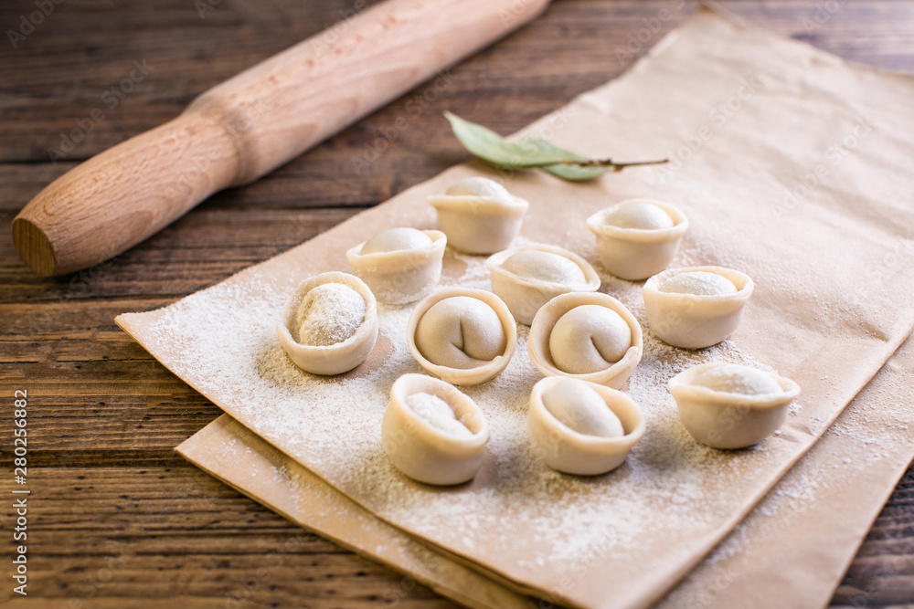 Raw Russian traditional dumplings on wooden background Raw Russian traditional dumplings on wooden background