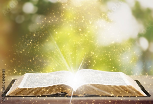 Open book on old wooden table.