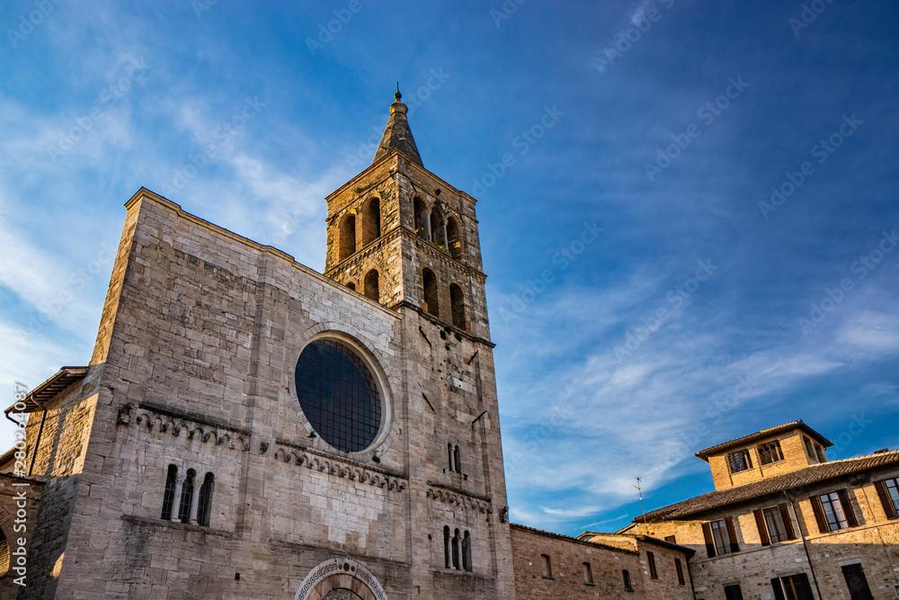 The Romanesque Church of San Michele in the medieval village of Bevagna. Perugia, Umbria, Italy. The travertine facade, with the large rose window and the Gothic bell tower.