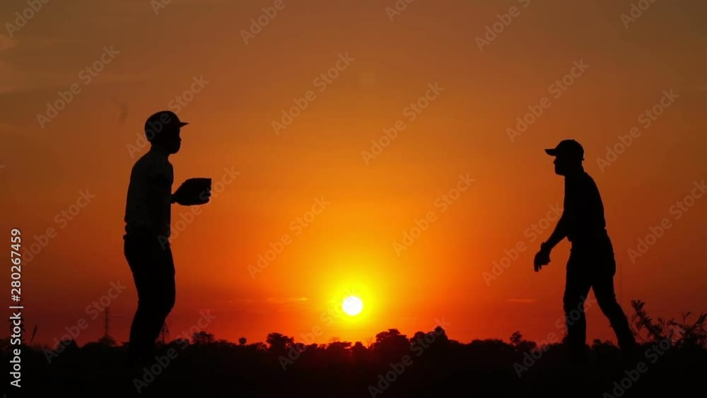 Silhouette baseball, two men were practicing throwing a baseball and getting together footage slow motion Silhouette baseball, two men were practicing throwing a baseball and getting together footage slow motion