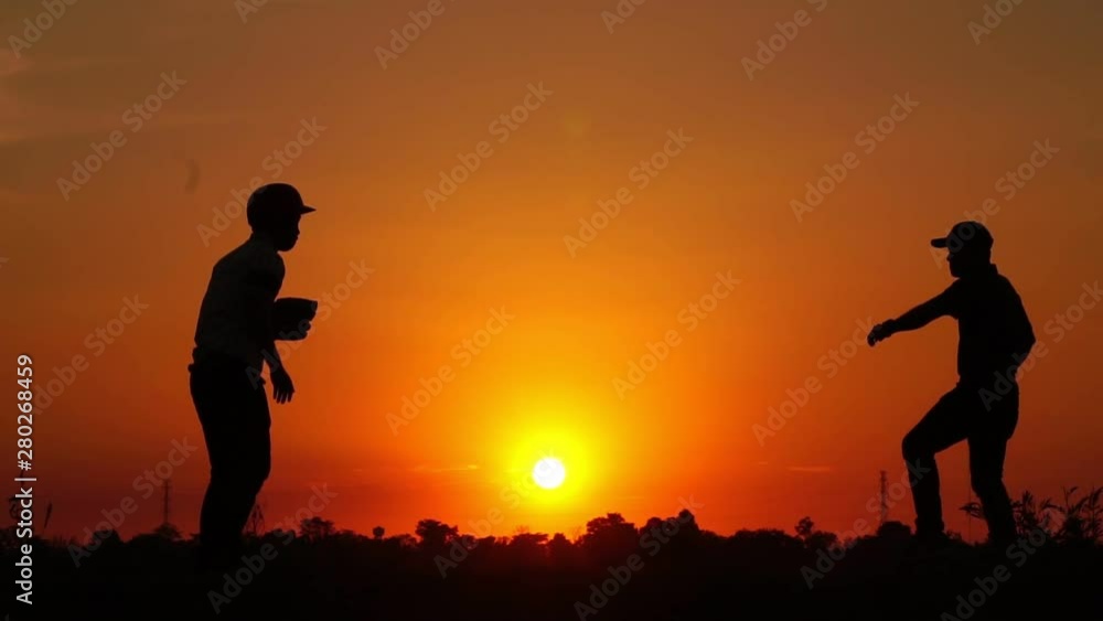 Silhouette baseball, two men were practicing throwing a baseball and getting together footage slow motion Silhouette baseball, two men were practicing throwing a baseball and getting together footage slow motion