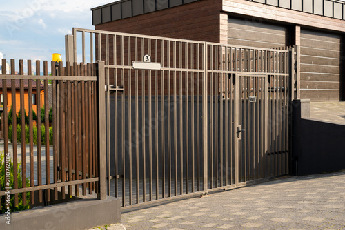 metal gate with automatic opening on the road  to the courtyard next to the garages