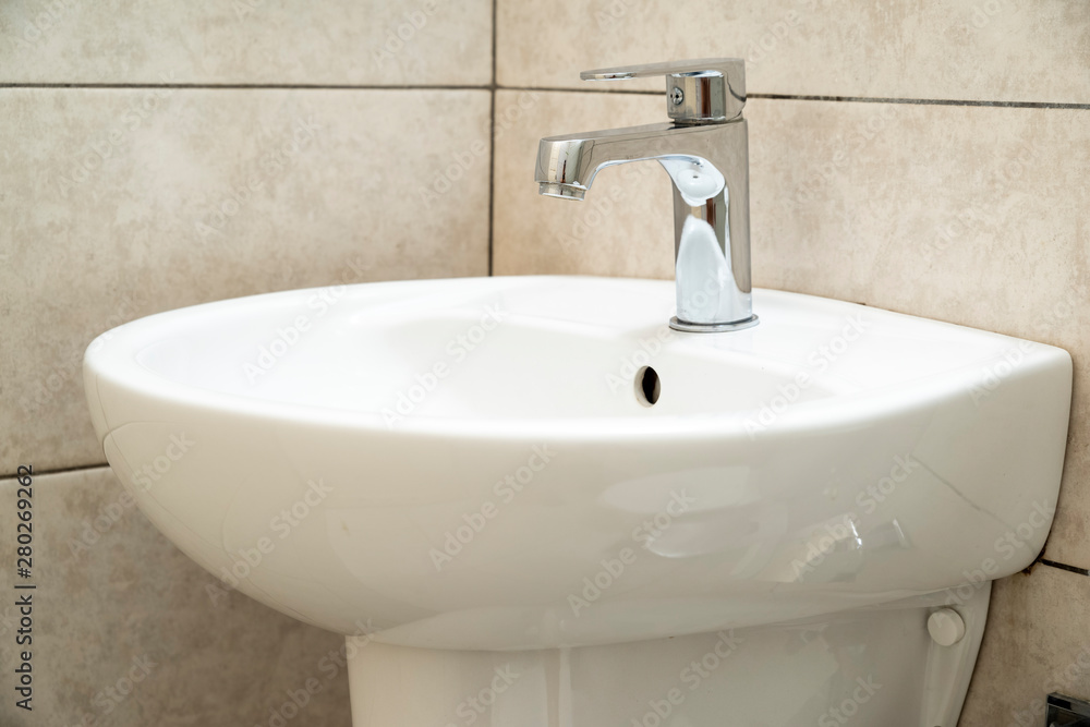 white ceramic washbasin with chrome faucet in the bathroom white ceramic washbasin with chrome faucet in the bathroom