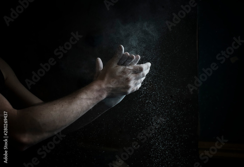 Man holding his hands together rubbing chalk for climbing