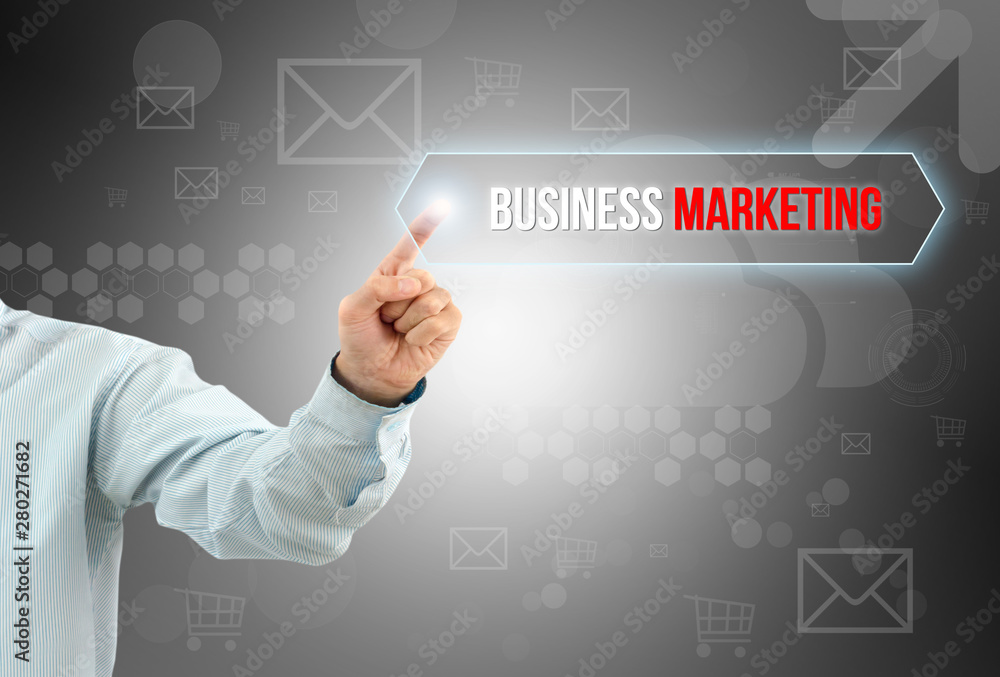 Obraz premium business man touch a button on an imaginary screen with text BUSINESS MARKETING