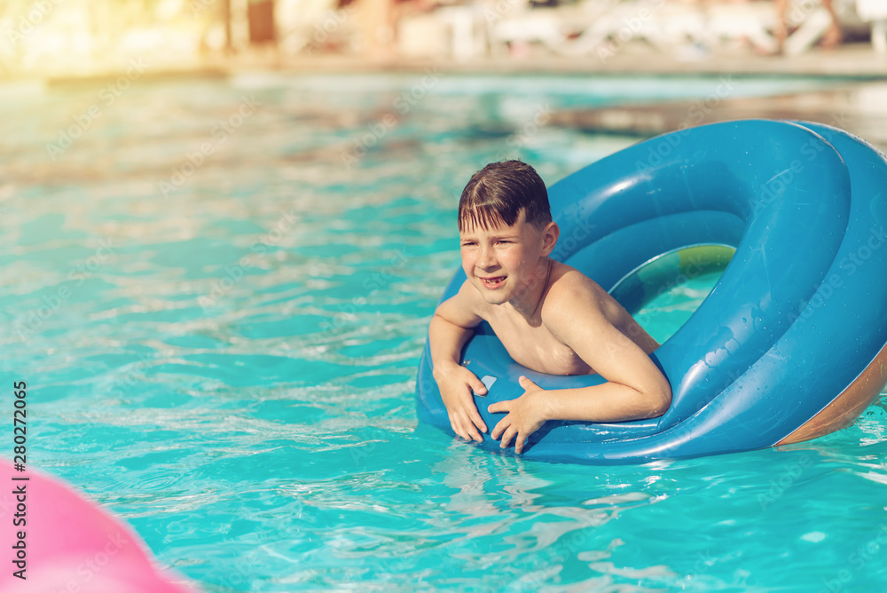 Summer vacation. Boy in rubber ring in swimming pool.