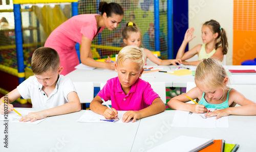 Kids sitting and listening teacher in elementary school
