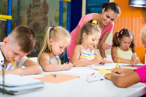 Careful children drawing on lesson in class room