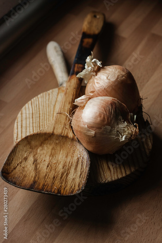ONIONS ON TABLE AND WOODEN SPOON