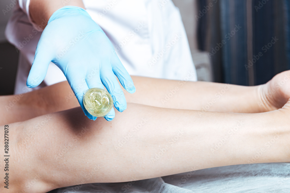 Waxing on a woman's hand in a sterile glove Waxing on a woman's hand in a sterile glove
