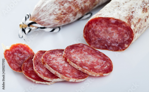 Fresh spanish longaniza sausages cut in slices on a white surface
