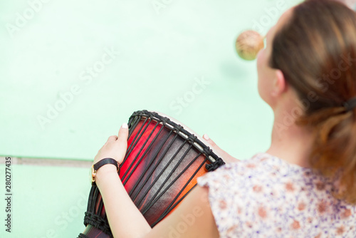 The girl plays the Djembe drum photo