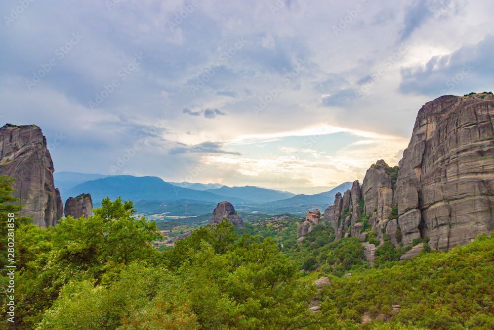 Meteora - incredible sandstone rock formations.  The Meteora area is on UNESCO World Heritage List since 1988. Valley between rocks at sunset. Greece